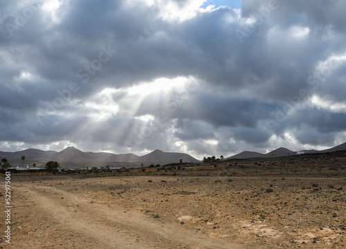 View of Los Ajaches from Puerto del Carmen in Lanzarote with sunbeams through the clouds