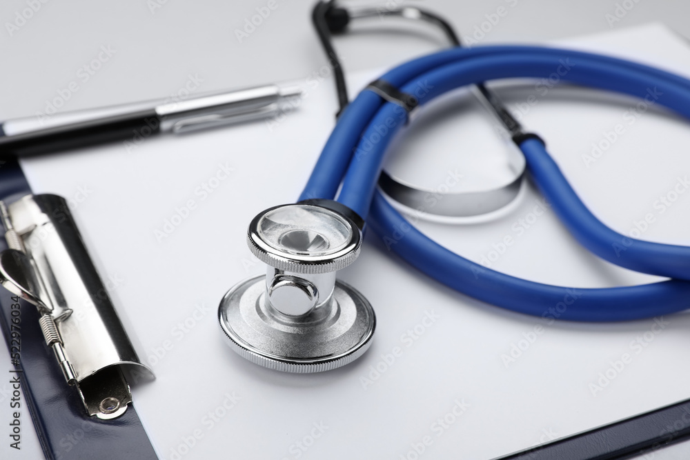 Stethoscope and clipboard on white background, closeup Stethoscope and clipboard on white background, closeup