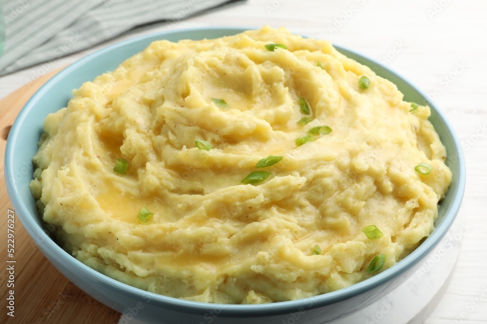 Bowl of tasty mashed potatoes with onion served on white wooden table, closeup Bowl of tasty mashed potatoes with onion served on white wooden table, closeup