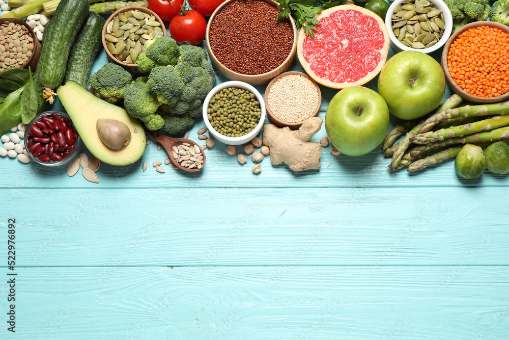 Fresh vegetables, fruits and seeds on light blue wooden table, flat lay. Space for text - obrazy, fototapety, plakaty 