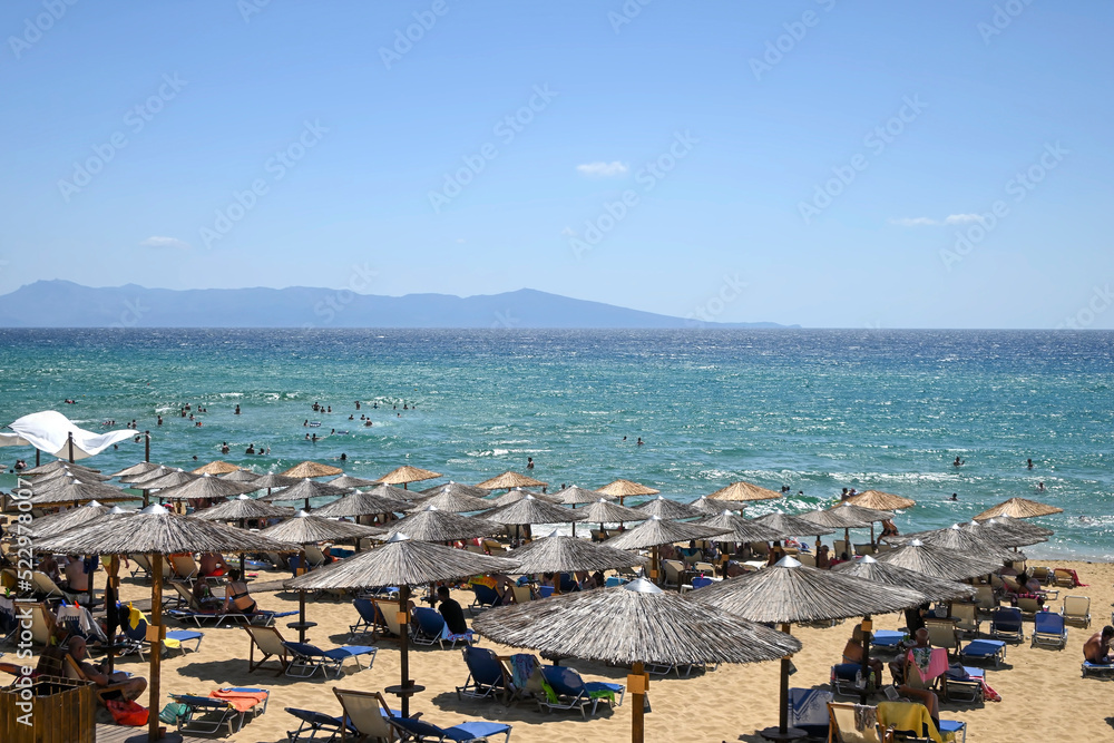 popular beach resort with sunbeds and straw umbrellas