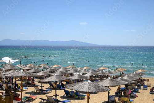 popular beach resort with sunbeds and straw umbrellas © conzorb