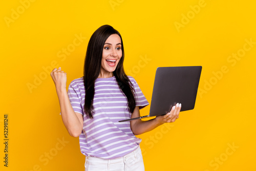 Photo of positive lady fan arm hold netbook watch online football game support rejoice hooray isolated on yellow color background