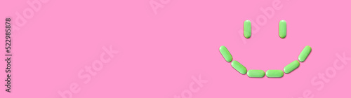 Smiling face lined with pills or dietary supplements. Green multivitamin or calcium tablets. Positive bright banner for the site header. Place for your text
