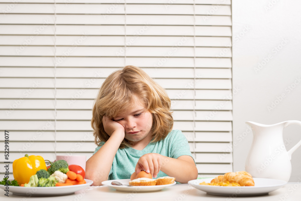 Portrait of kid with no appetite. Concept of loss of appetite. Child eats organic food. Healthy vegetables with vitamins. Proper kids nutrition concept. Portrait of kid with no appetite. Concept of loss of appetite. Child eats organic food. Healthy vegetables with vitamins. Proper kids nutrition concept.