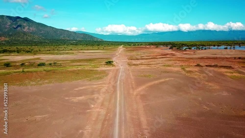 Fly Over Dirt Road In Safari Tours Near Lake Magadi In Kenya, East Africa. Aerial Drone Shot photo