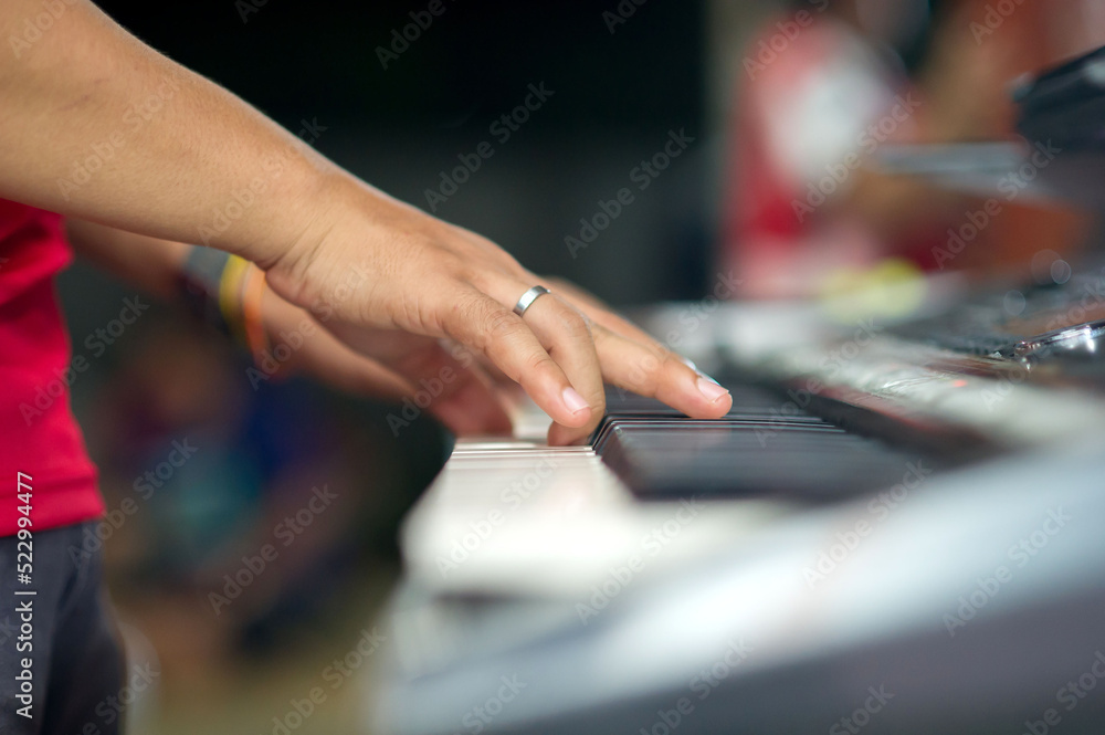 Closeup hands playing the keyboard or piano on brand music instrument background, music concept Closeup hands playing the keyboard or piano on brand music instrument background, music concept