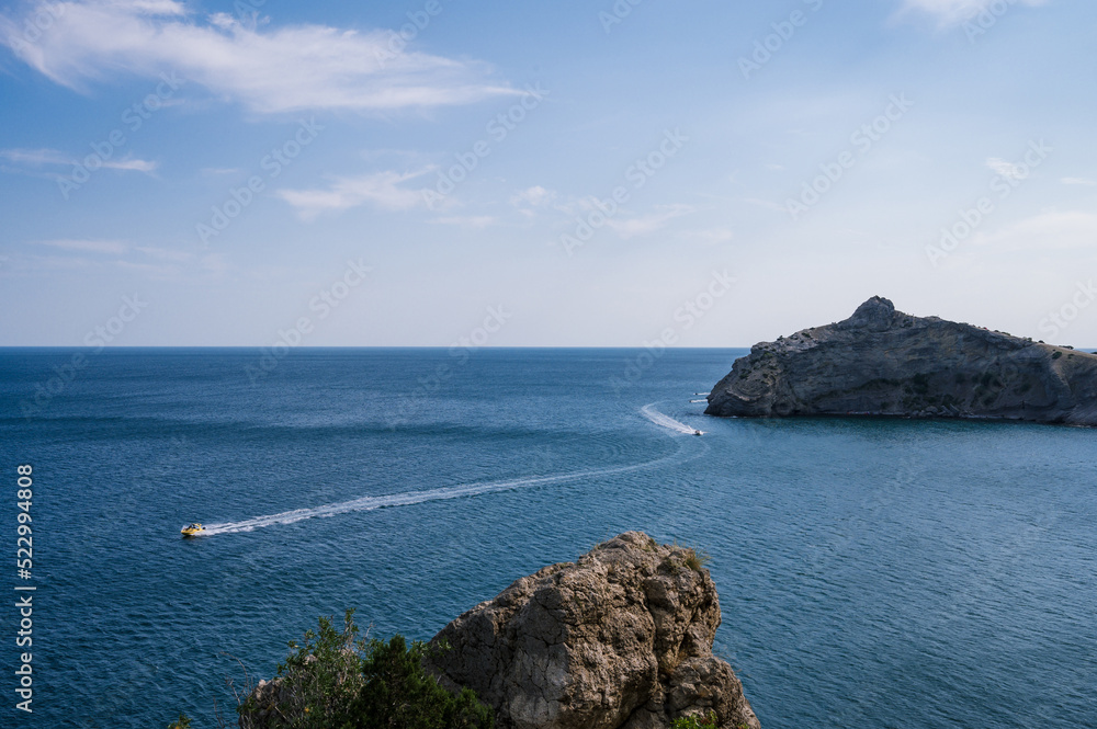 Beautiful landscape of Crimea nature. Rocky mountains in the Black sea. Pleasure boats.