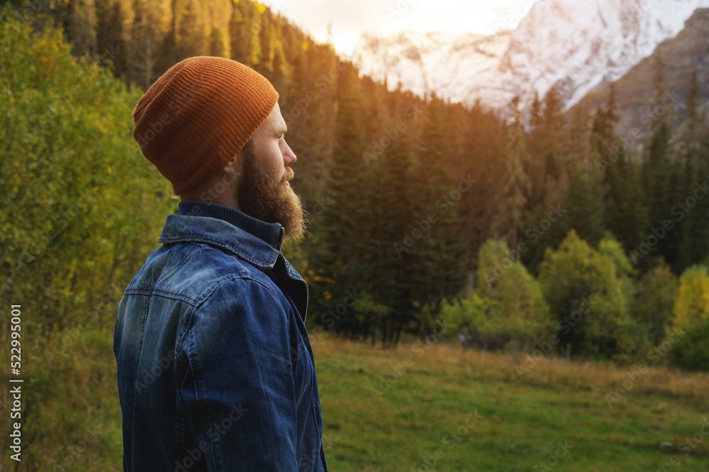 A bearded man stand on a log alone in the mountains. Healthy lifestyle concept, sunny mountain landscape A bearded man stand on a log alone in the mountains. Healthy lifestyle concept, sunny mountain landscape