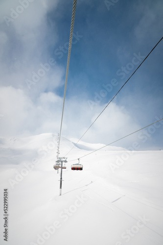 ski lift high in the clouds against the backdrop of snow-capped mountains
