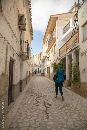 A tourist with child in the carrier walking on the desolated street in Alcalá del Júcar in Albacete province, Spain. © MassimilianoF