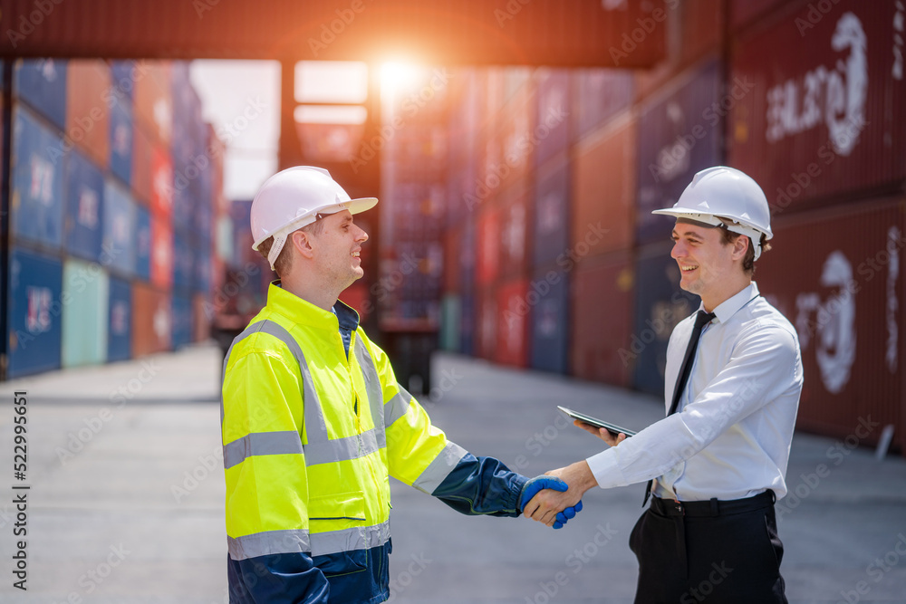 Businessman and Technician Shaking hands after the inspection are complete at the container yard warehouse. Businessman and Technician Shaking hands after the inspection are complete at the container yard warehouse.