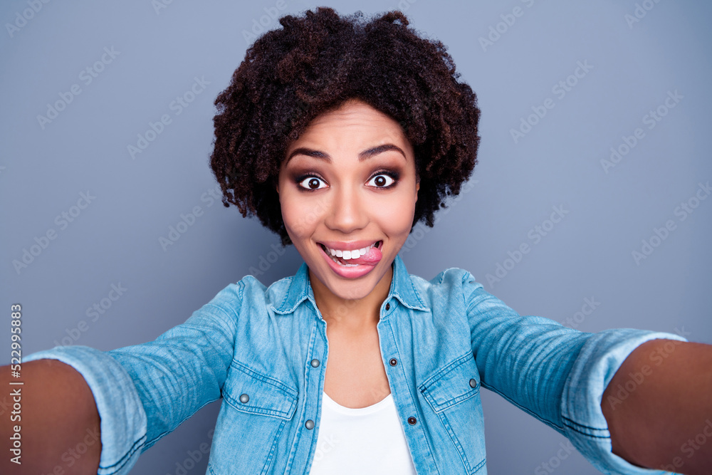 Portrait of carefree positive girl take selfie biting tongue have good mood isolated on grey color background Portrait of carefree positive girl take selfie biting tongue have good mood isolated on grey color background
