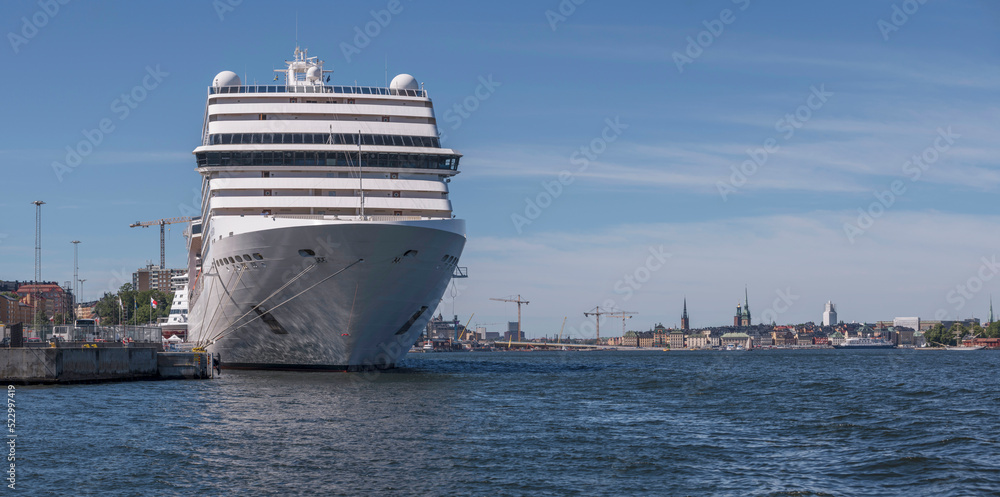 Naklejka premium The cruise ship MCS Poesia at the pier Masthamnen and the old town Gamla Stan in background, a sunny summer day in Stockholm