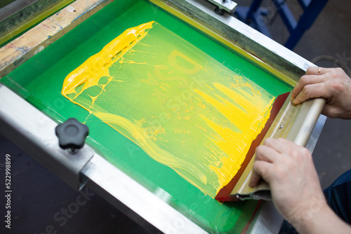 Obraz na plátne Serigraphy silk screen print process at clothes factory