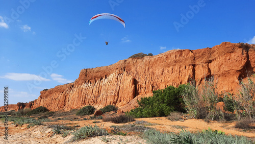 Un parapentiste au-dessus des falaises de la plage d'Albufeira en Algarve au Portugal