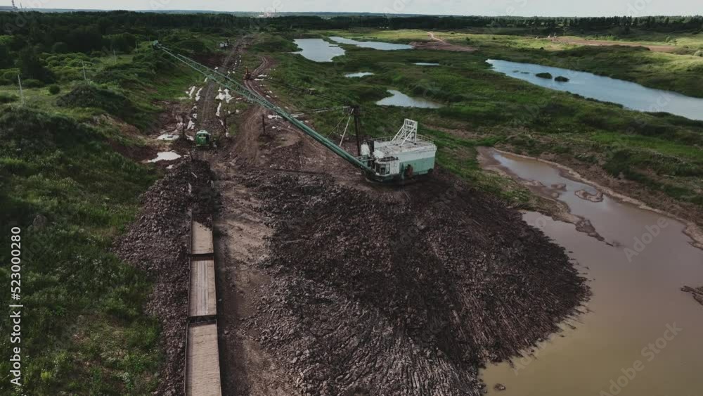 Open-pit mining. Dragline excavator load clay in freight train. Clay ...