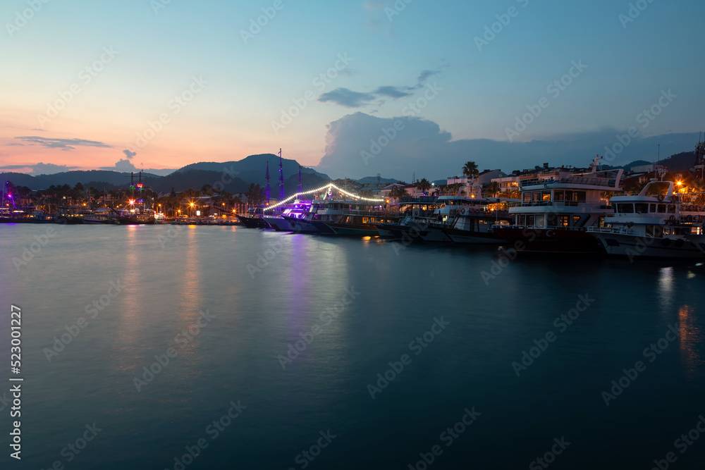 Beautiful and colorful sunset on the sea. Small sea town. Beautiful sky and mountains. Calm summer evening.