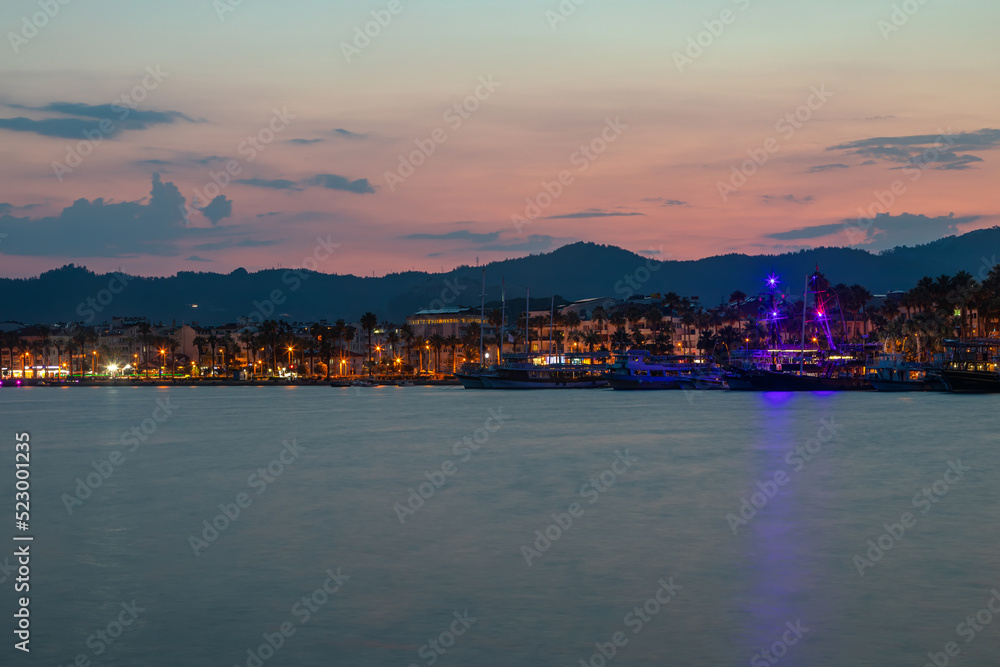 Beautiful and colorful sunset on the sea. Small sea town. Beautiful sky and mountains. Calm summer evening.