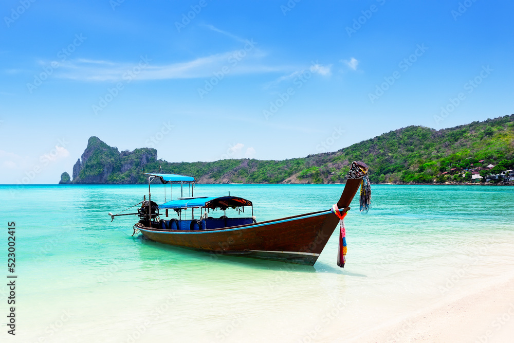 Thai traditional wooden longtail boat and beautiful sand beach at Koh Phi Phi island in Krabi province in Thailand.