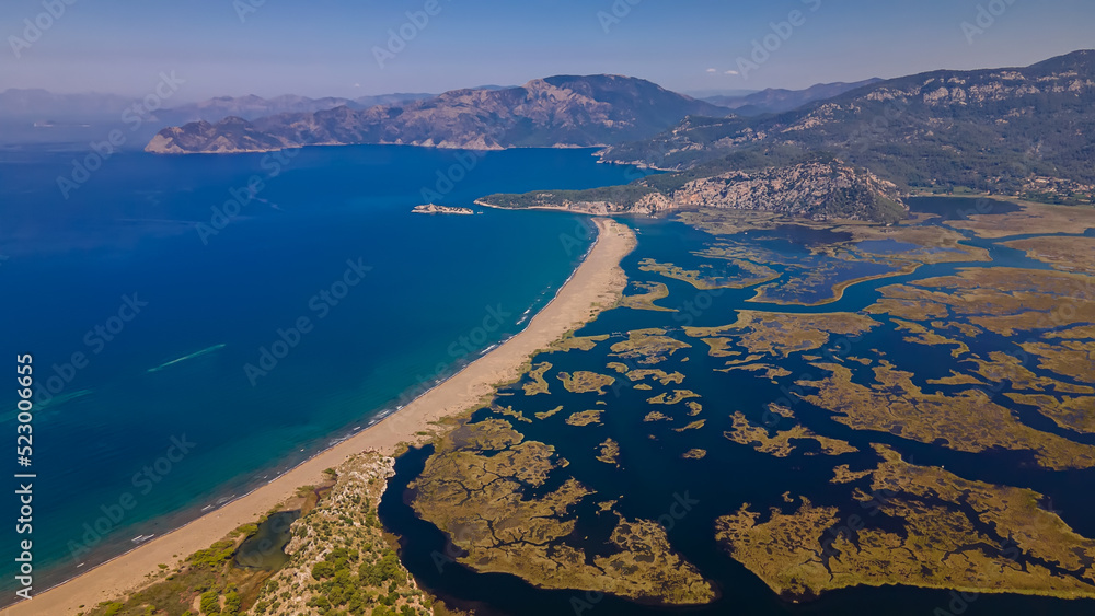 Fototapeta premium Beautiful seashore. Islands in the distance. Colorful blue sea. The beauty of Turkey. Beautiful rocks and mountains. Sunny clear day. Beautiful water.