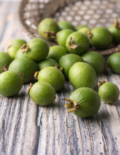 wild guava fruits scattered on a wooden surface  freshly harvested common tropical fruits that packed with nutrients  soft-focus background with copy space