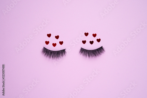 Creative concept beauty fashion photo of lashes extensions brush on pink background.
