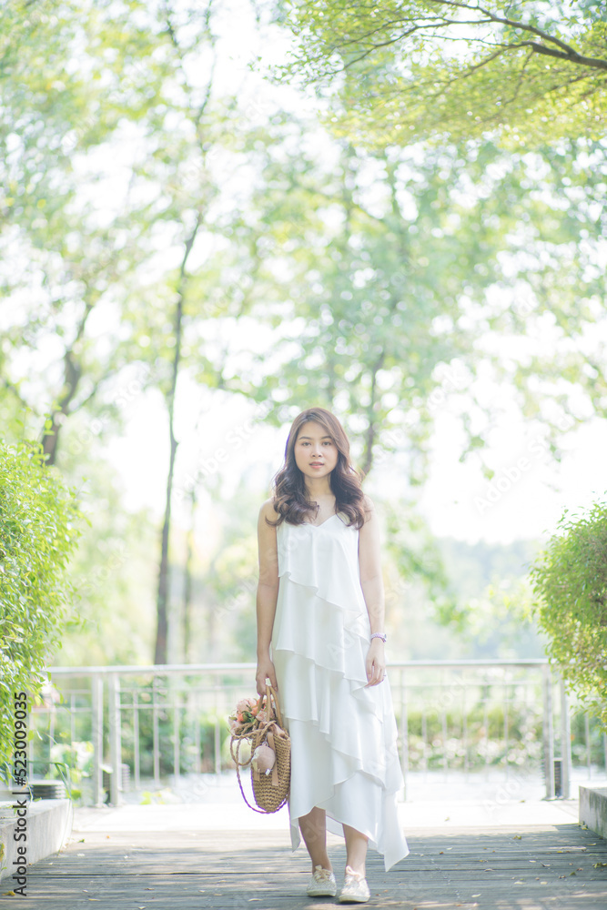 Pretty asian fashion women relax in green city park sunny day