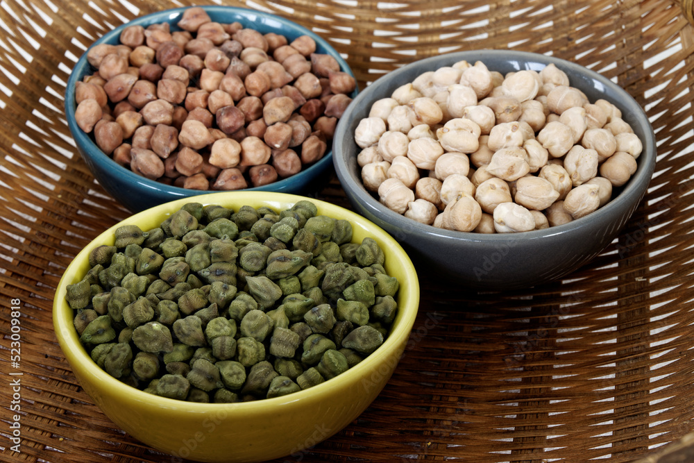 Assortment of dry chickpea piles in bowls. Three different chick pea kinds: green, kala chana and white. Assortment of dry chickpea piles in bowls. Three different chick pea kinds: green, kala chana and white.