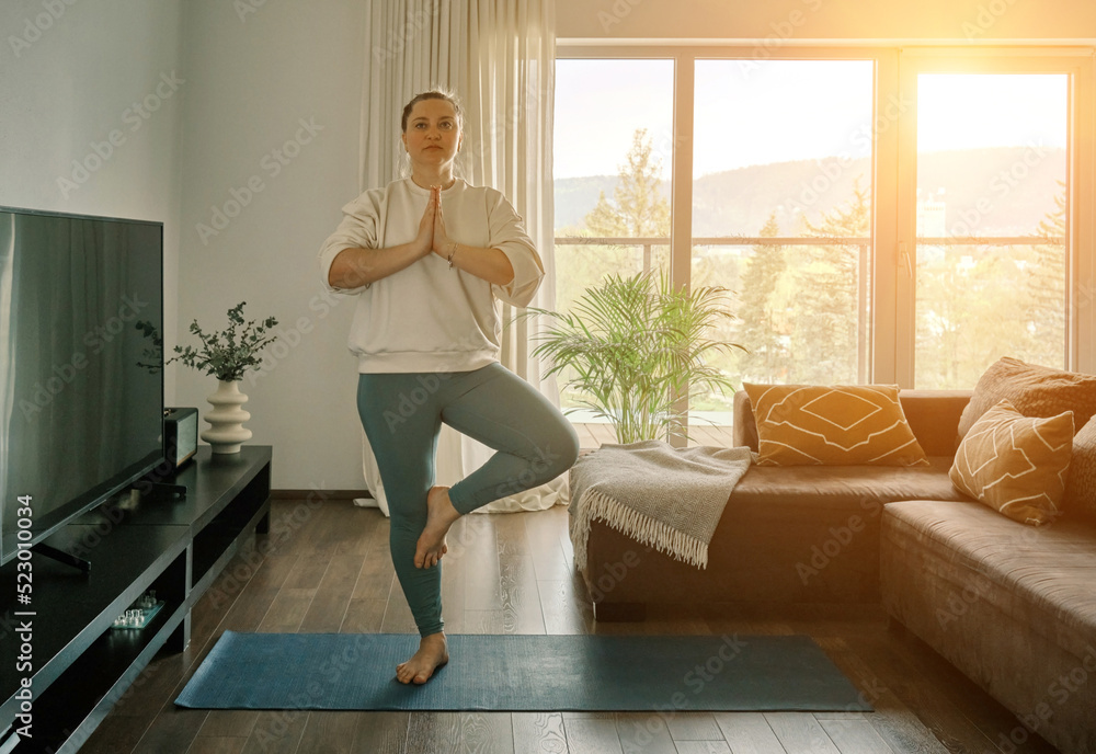 Woman doing online yoga at home. Female teaches asana in video conference. Health care, authenticity, sense of balance and calmness. Woman doing online yoga at home. Female teaches asana in video conference. Health care, authenticity, sense of balance and calmness.