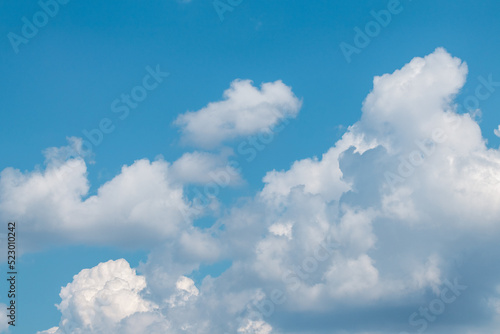 Fluffy white high clouds on bright blue sky, cloudscape background. Skyscape natural heavenly scenery