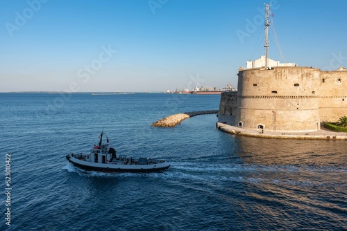 Small Tug  thet exits from the Taranto Canalboat in summer, in front of the Aragonese Castle photo