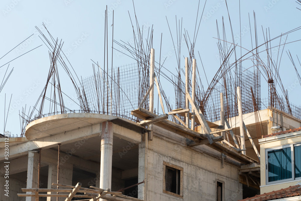 steel reinforcement sticking out of a concrete unfinished building on a construction site. steel reinforcement sticking out of a concrete unfinished building on a construction site.