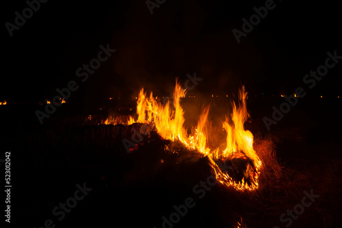 The fire burns the straw and the hay in the fields at night. in the northeastern part of Thailand southeast asia