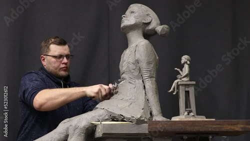 Man sculptor creates sculpt bust clay human woman sculpture. Statue craft creation workshop.