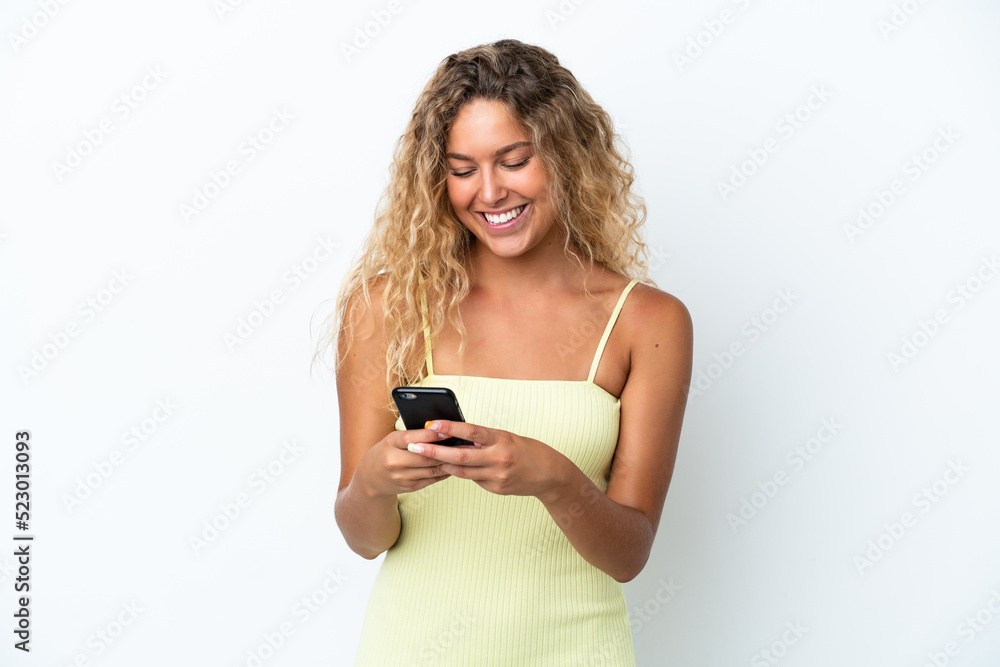 Girl with curly hair isolated on white background sending a message with the mobile Girl with curly hair isolated on white background sending a message with the mobile
