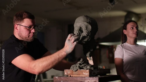 Man sculptor creates sculpt bust clay human woman sculpture. Statue craft creation workshop. Small business.