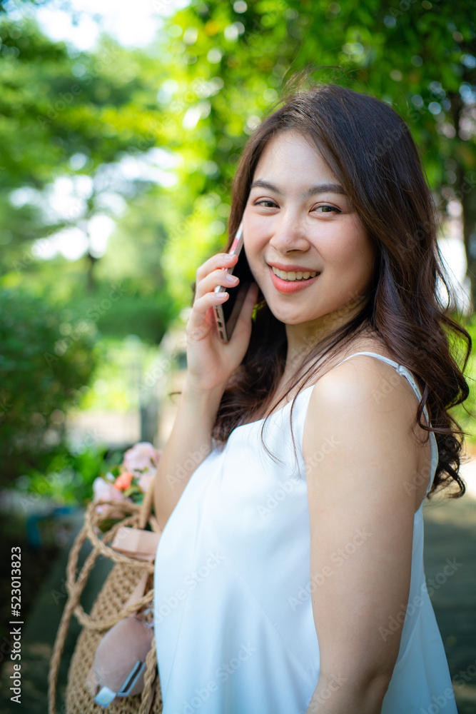 Beautiful asian women use smartphone in city green park outdoor recreation relax in city park Beautiful asian women use smartphone in city green park outdoor recreation relax in city park