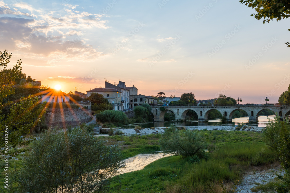 Soleil couchant sur le pont romain transversant le Vidourle à Sommières