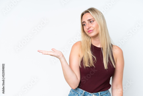 Young caucasian woman isolated on white background holding copyspace with doubts