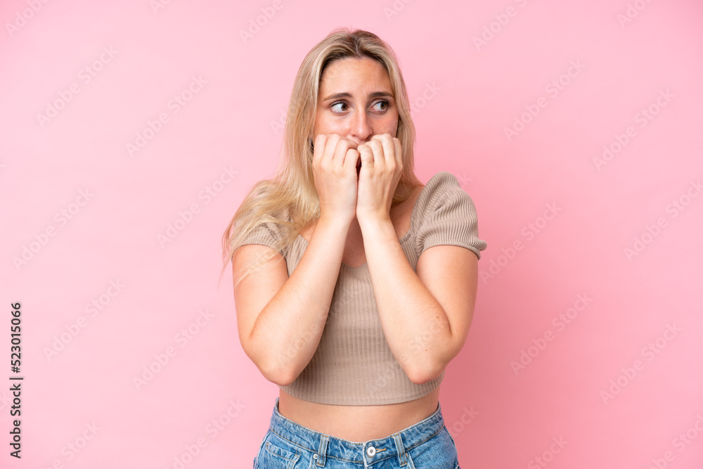 Young caucasian woman isolated on pink background nervous and scared putting hands to mouth Young caucasian woman isolated on pink background nervous and scared putting hands to mouth