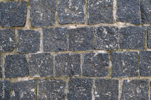 texture, background. The pavement of granite stone. Paved roadway street. any paved area or surface. Old cobblestone road pavement texture 