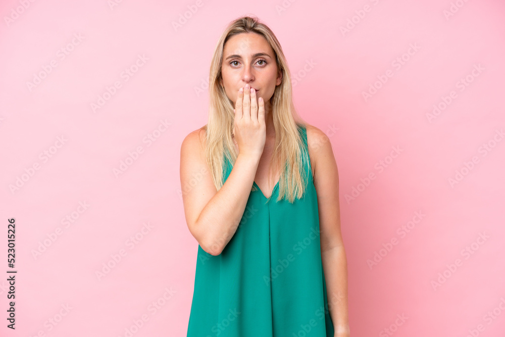 Young caucasian woman isolated on pink background covering mouth with hand Young caucasian woman isolated on pink background covering mouth with hand