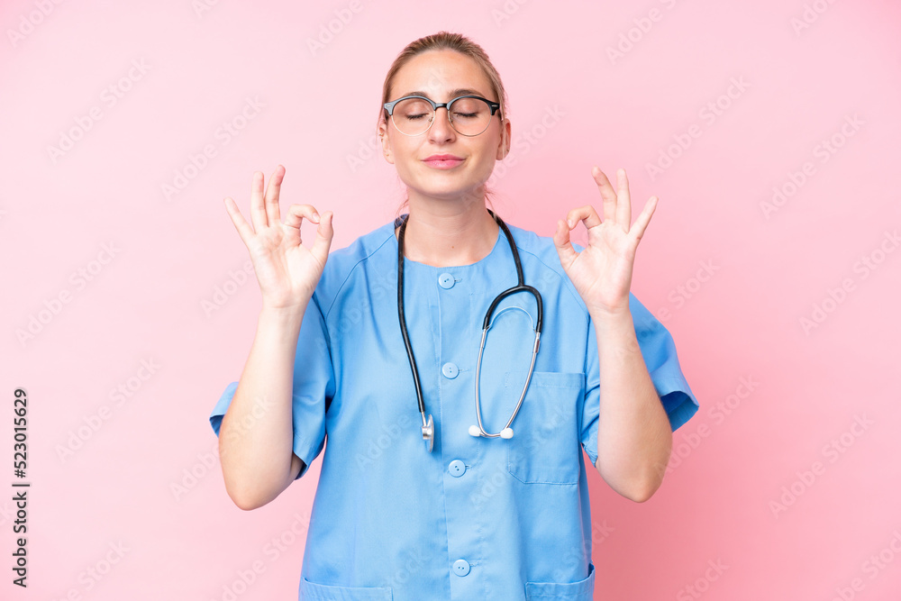 Young surgeon nurse woman isolated on pink background in zen pose Young surgeon nurse woman isolated on pink background in zen pose