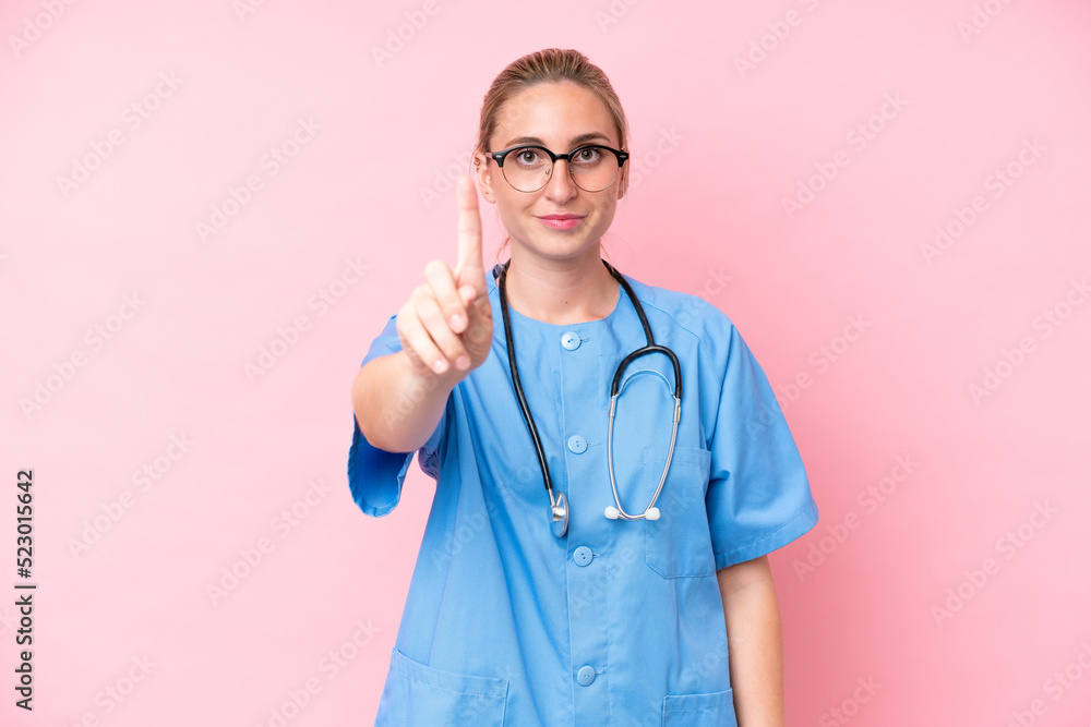 Young surgeon nurse woman isolated on pink background showing and lifting a finger Young surgeon nurse woman isolated on pink background showing and lifting a finger