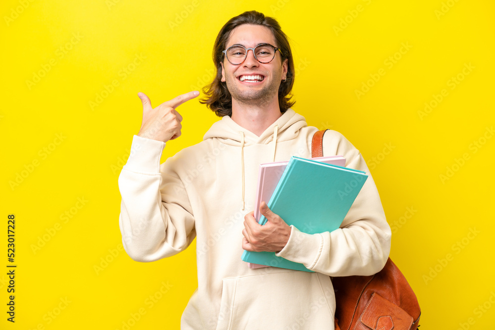 Young student handsome man isolated on yellow background giving a thumbs up gesture Young student handsome man isolated on yellow background giving a thumbs up gesture