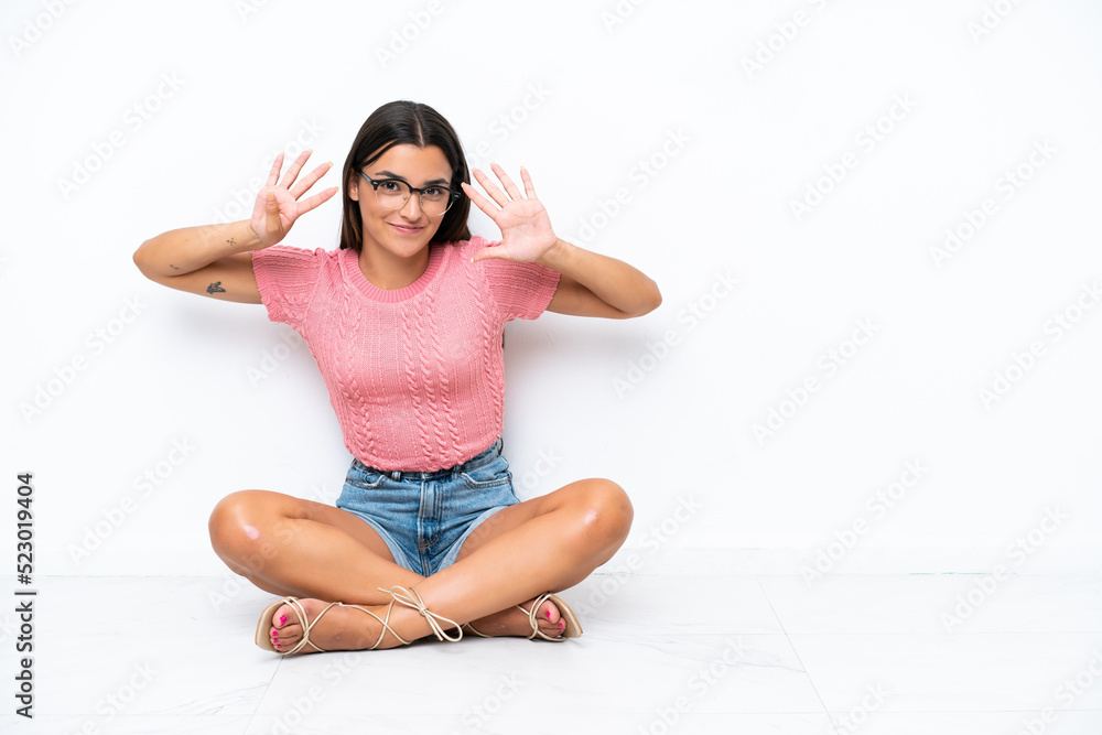 Young caucasian woman sitting on the floor isolated on white background counting nine with fingers Young caucasian woman sitting on the floor isolated on white background counting nine with fingers