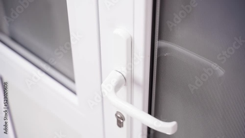 Clean white plastic doors with opaque windows, close-up door handle. Smooth camera movement