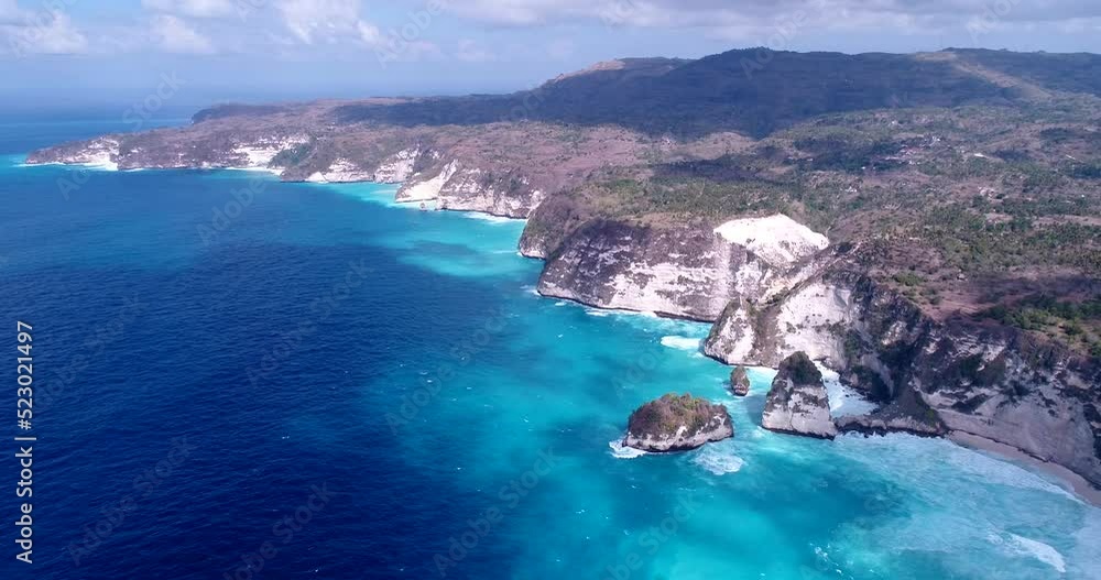 Aerial shot of coast with vertical cliffs, turquoise water and waves crashing Aerial shot of coast with vertical cliffs, turquoise water and waves crashing