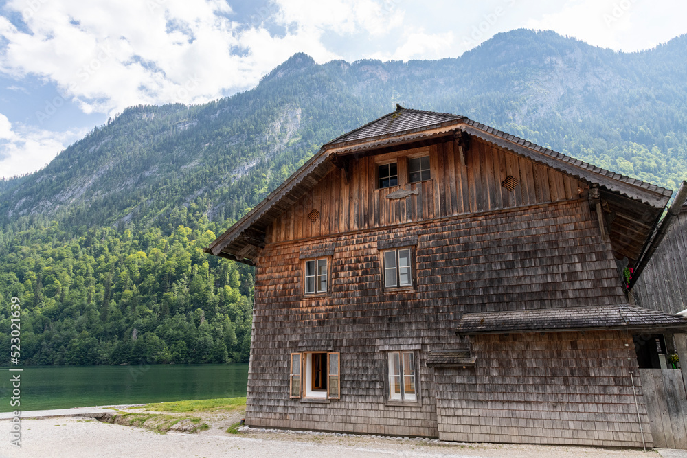 großes antikes Holzhaus mit Bergkulisse im Hintergrund